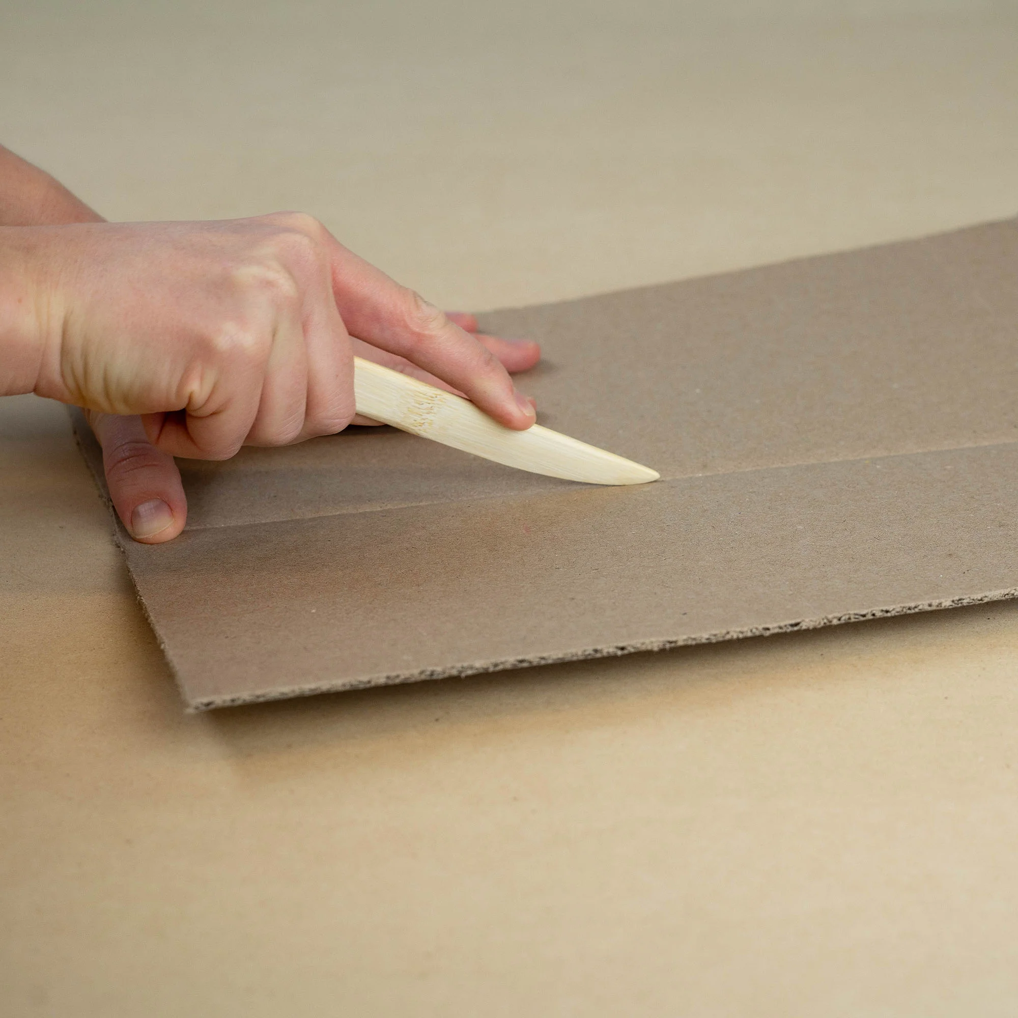 Scoring_Tool_in_Action_2 Scoring tool creasing a cardboard sheet