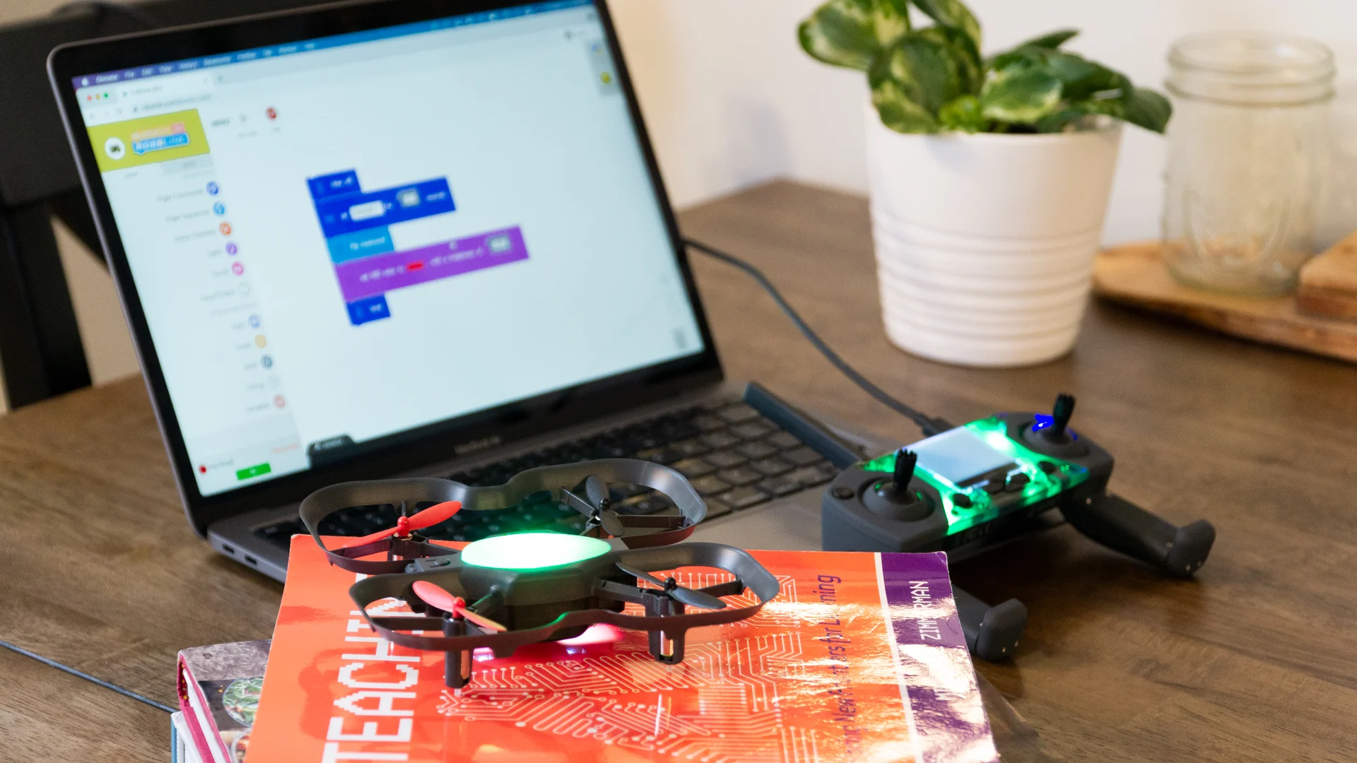 CoDrone EDU and its Smart Controller beside a laptop running Blockly