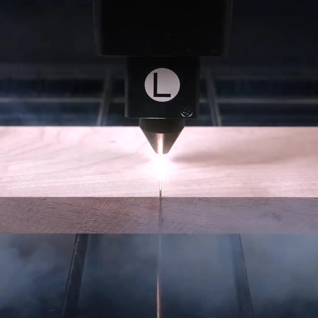 Laser head cutting a walnut board